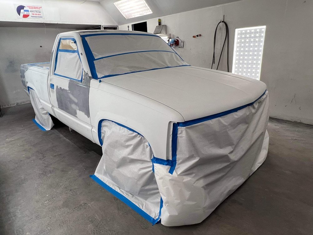 Pickup truck masked with blue tape before painting